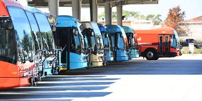 A line of busses at a depot.